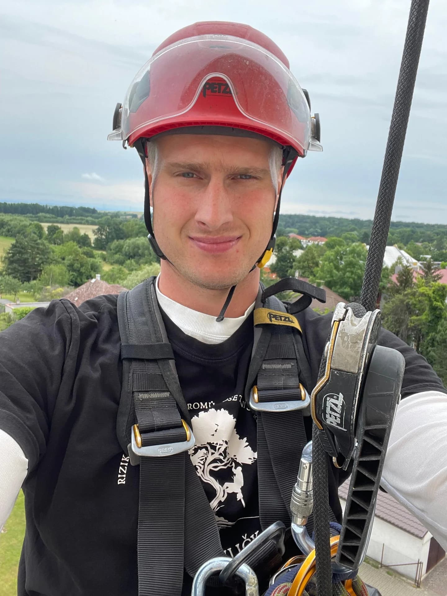 Arborista s helmou Petzl ve výšce